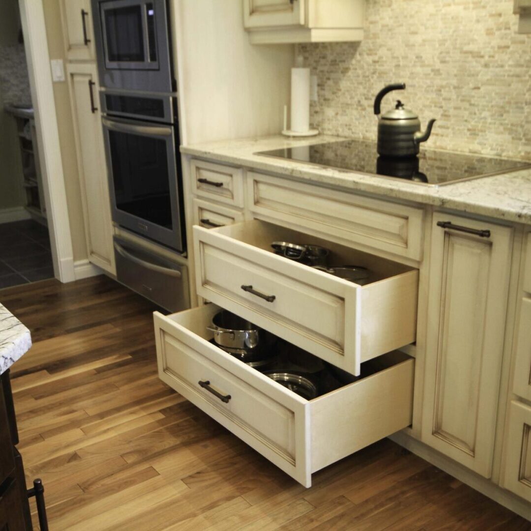 A kitchen with wooden floors and white cabinets.